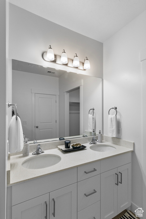 Bathroom featuring a sink, double vanity, and visible vents