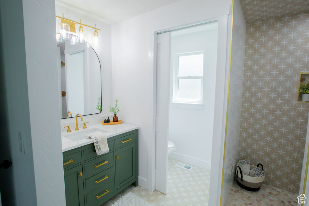 Full bath featuring vanity, toilet, and a shower