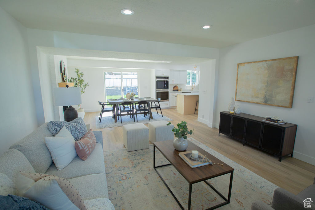 Living area with light wood-style floors, recessed lighting, and baseboards