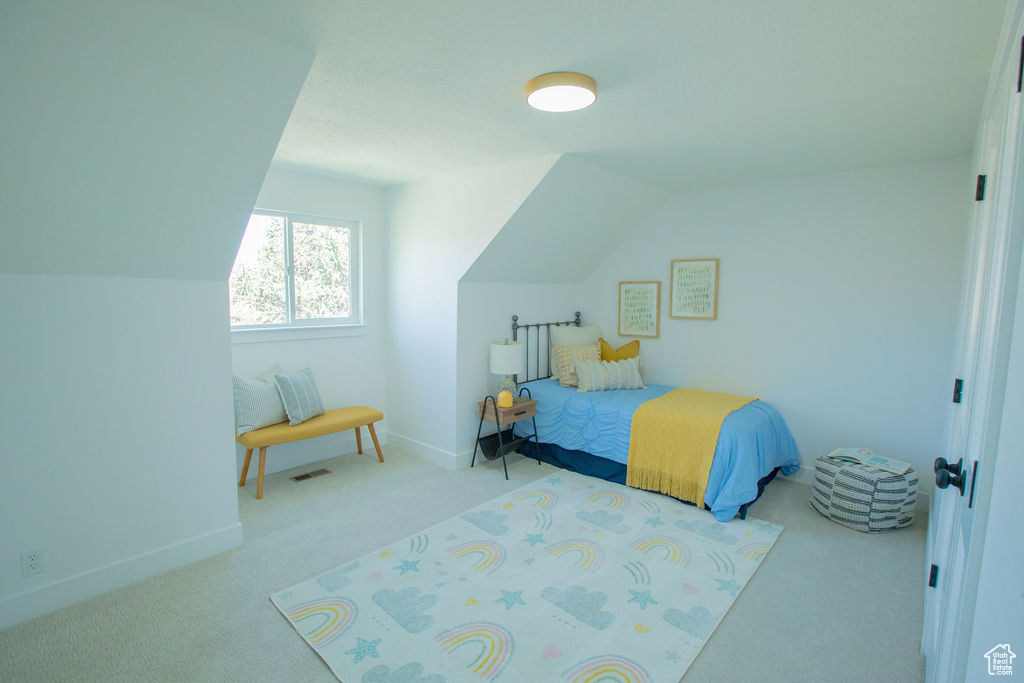 Carpeted bedroom featuring baseboards and lofted ceiling