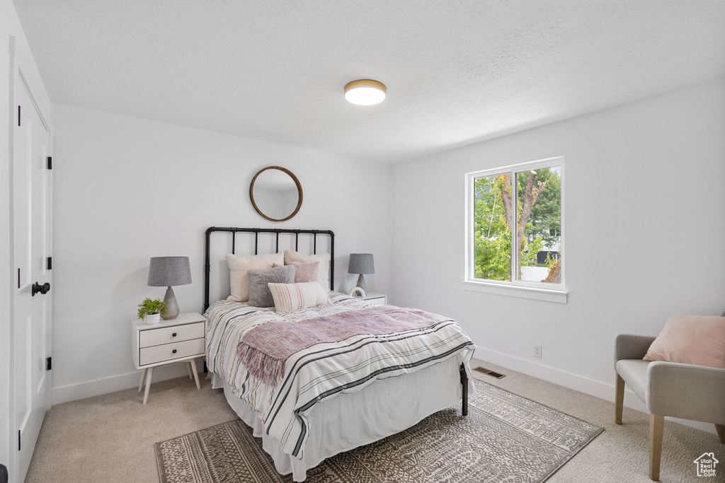 Bedroom with light colored carpet and baseboards