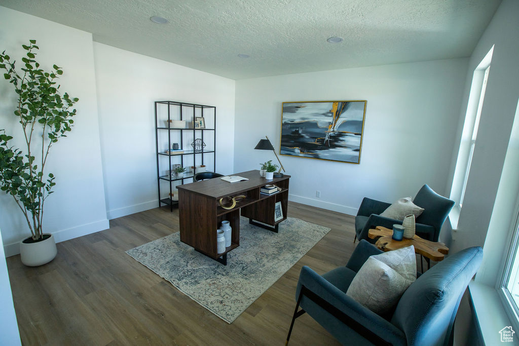 Home office with a textured ceiling, baseboards, and dark wood-style floors