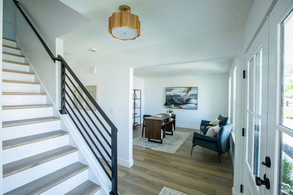 Foyer entrance featuring wood finished floors, baseboards, and stairway