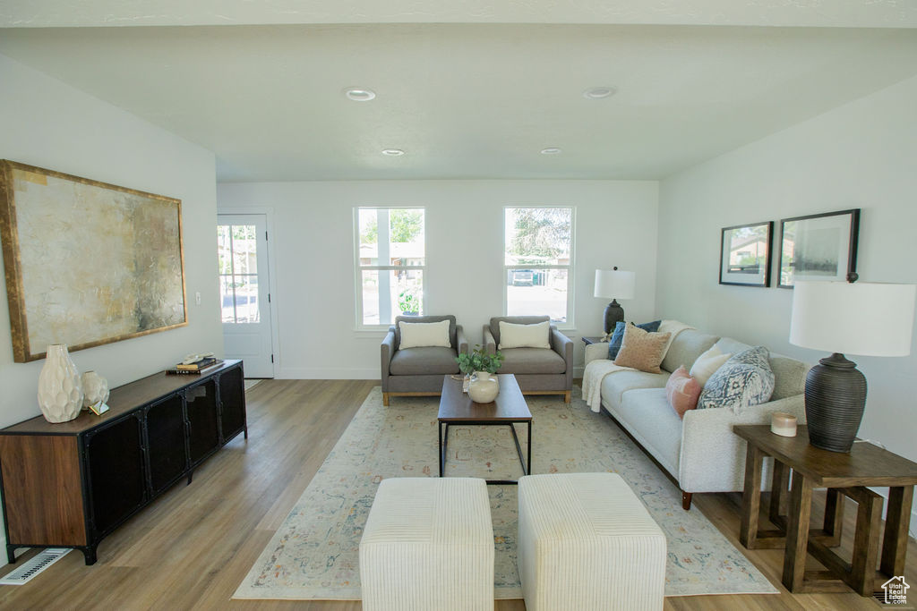 Living room featuring light wood finished floors, healthy amount of natural light, recessed lighting, and baseboards