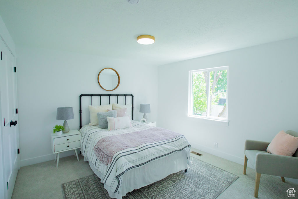 Bedroom featuring light carpet and baseboards