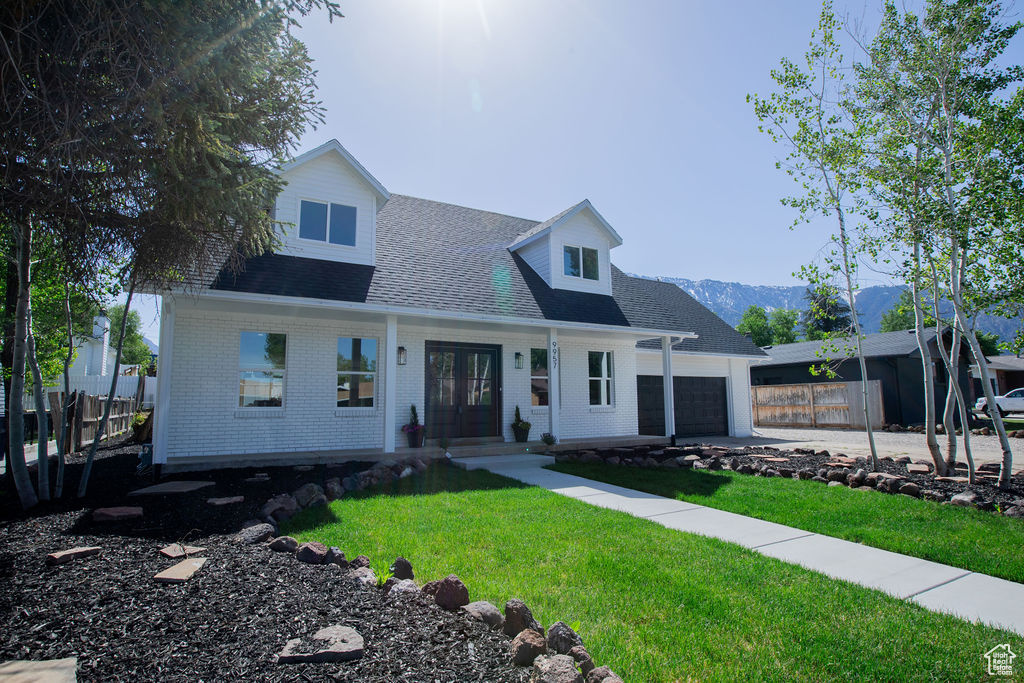 Cape cod house featuring french doors, a garage, roof with shingles, a mountain view, and brick siding