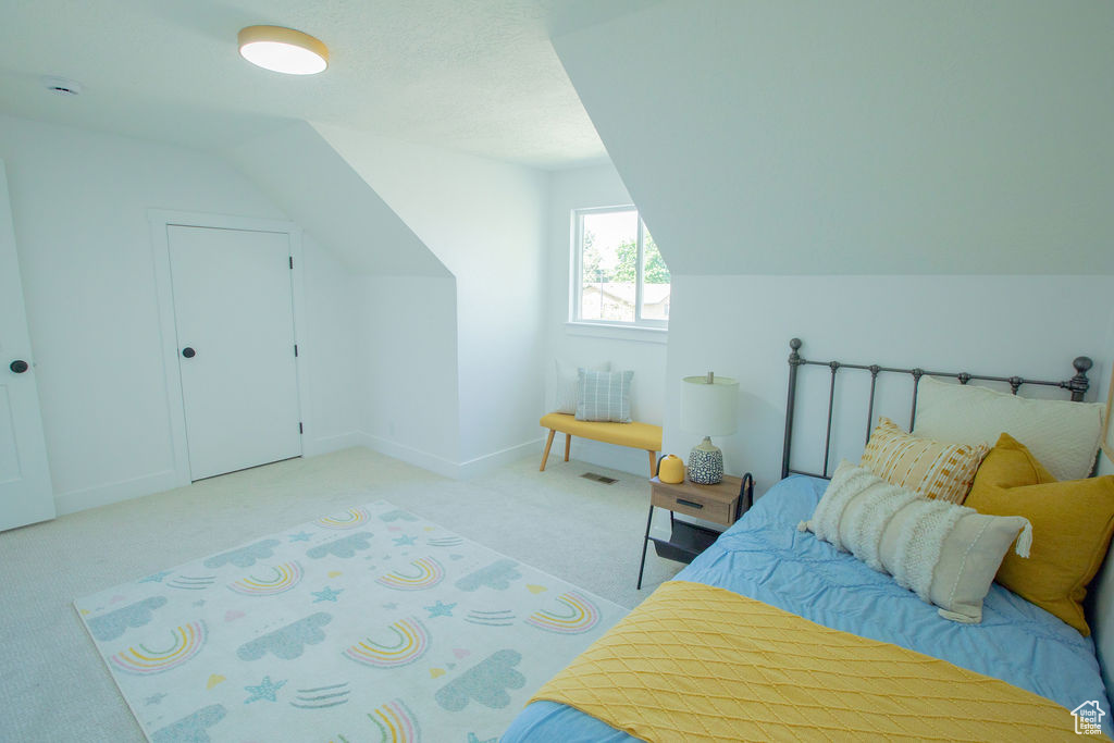 Bedroom with carpet, baseboards, and vaulted ceiling