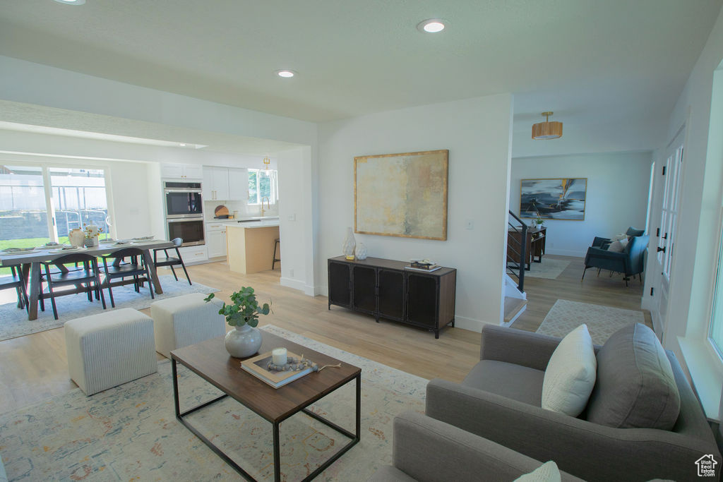 Living room with light wood-style floors and recessed lighting