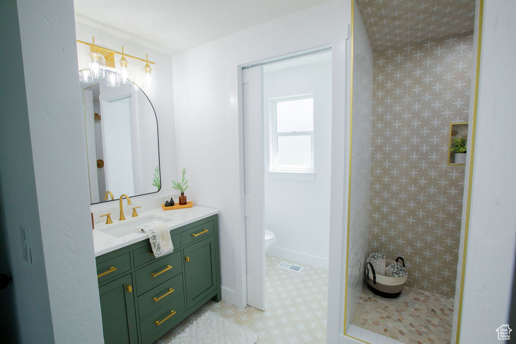Full bath featuring vanity, toilet, and a shower