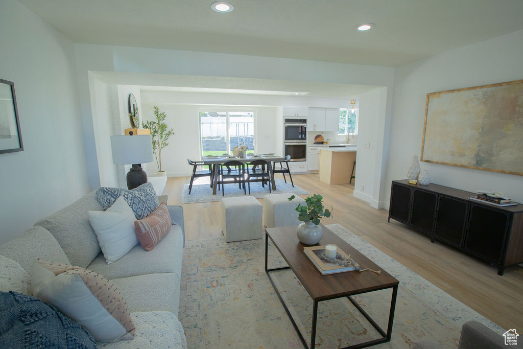 Living room with light wood-style floors, recessed lighting, and baseboards