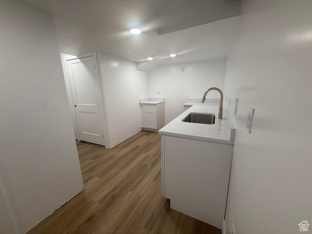 Laundry area with a sink and wood finished floors