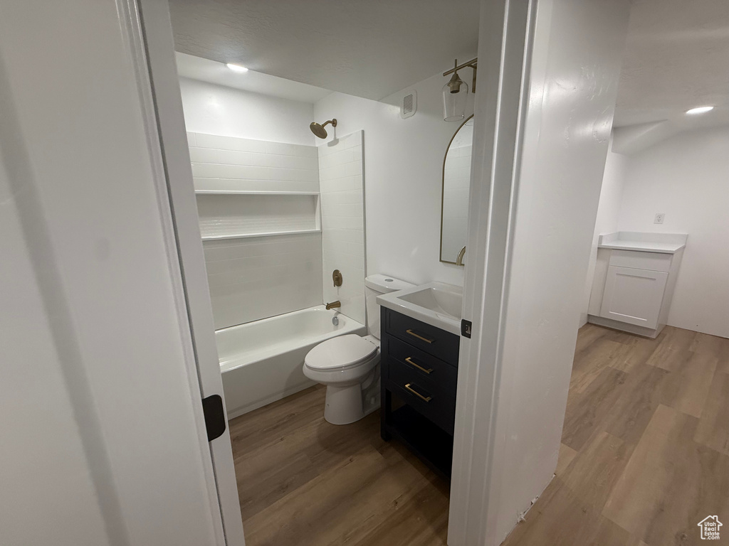 Full bathroom featuring wood finished floors, vanity, toilet, and shower / bathtub combination