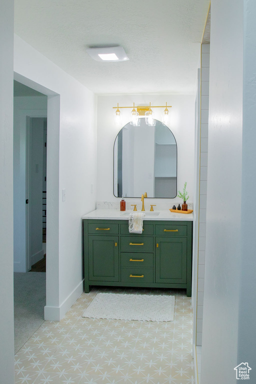 Bathroom featuring tile patterned floors, vanity, and baseboards