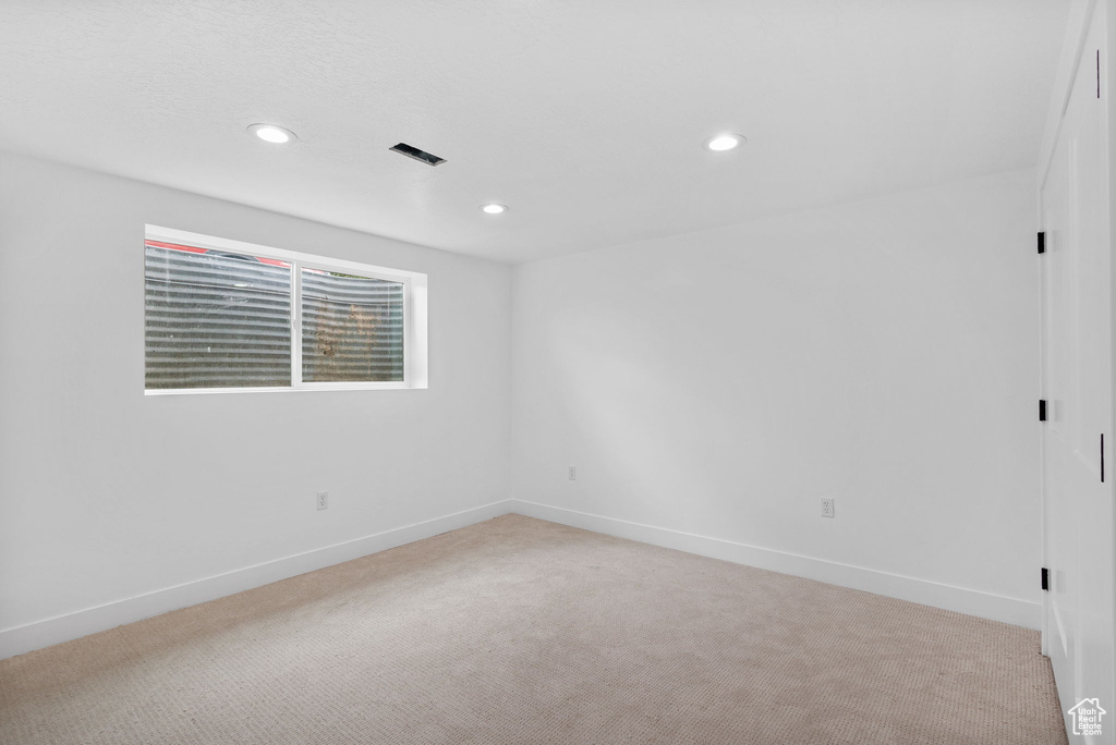 Unfurnished room featuring light carpet, recessed lighting, and baseboards