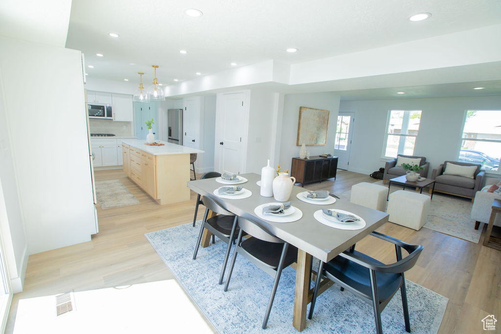 Dining room featuring healthy amount of natural light, light wood-style flooring, and recessed lighting