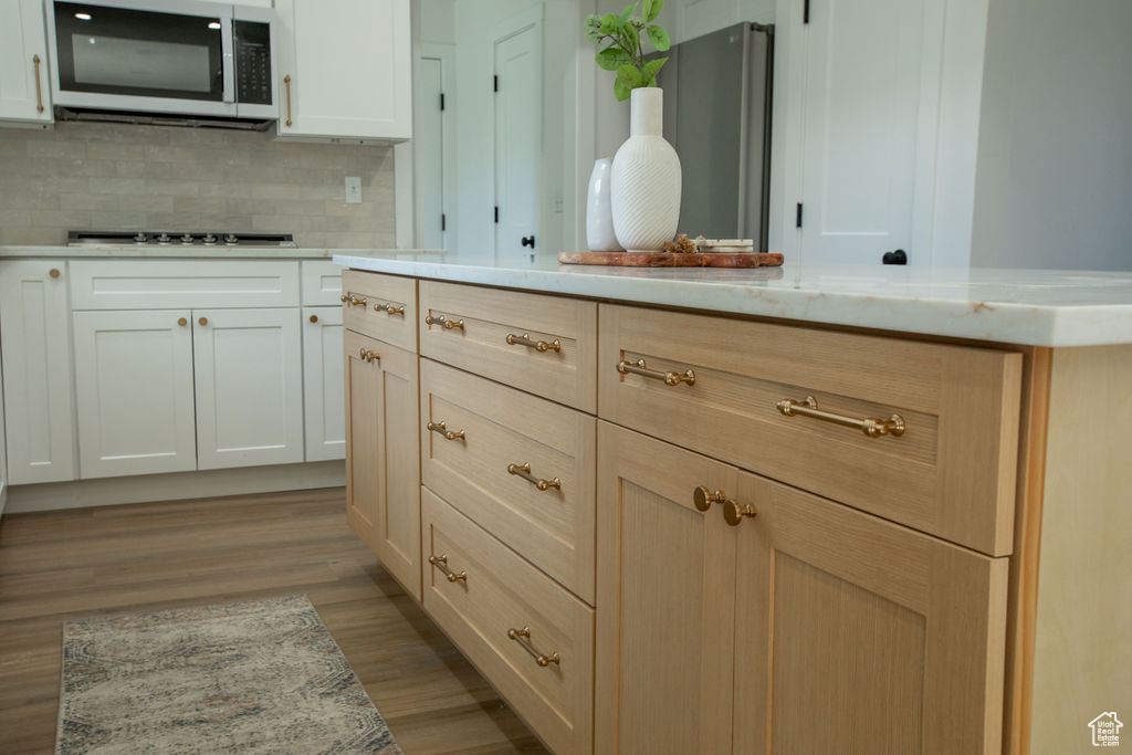 Bathroom with decorative backsplash and wood finished floors