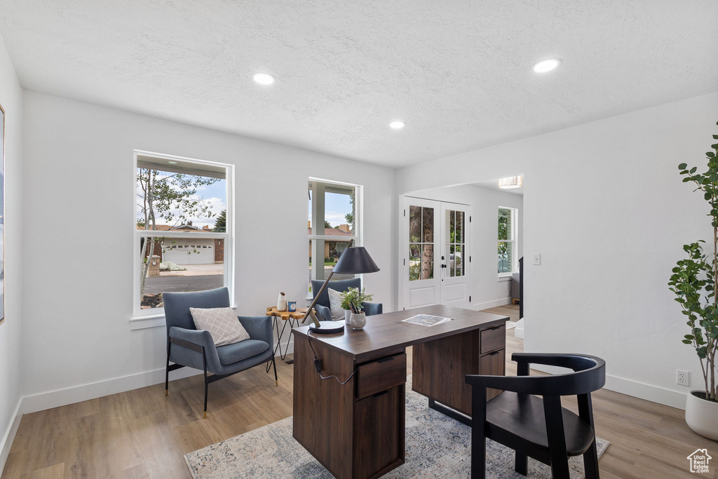 Office with light wood-style flooring, healthy amount of natural light, recessed lighting, a textured ceiling, and baseboards