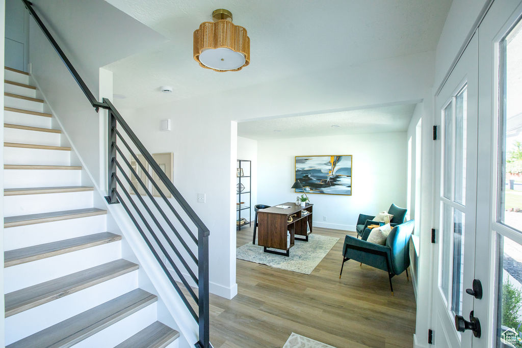 Entrance foyer featuring wood finished floors, stairway, baseboards, and plenty of natural light