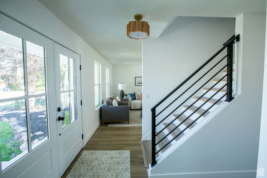 Foyer entrance with stairway, wood finished floors, and baseboards