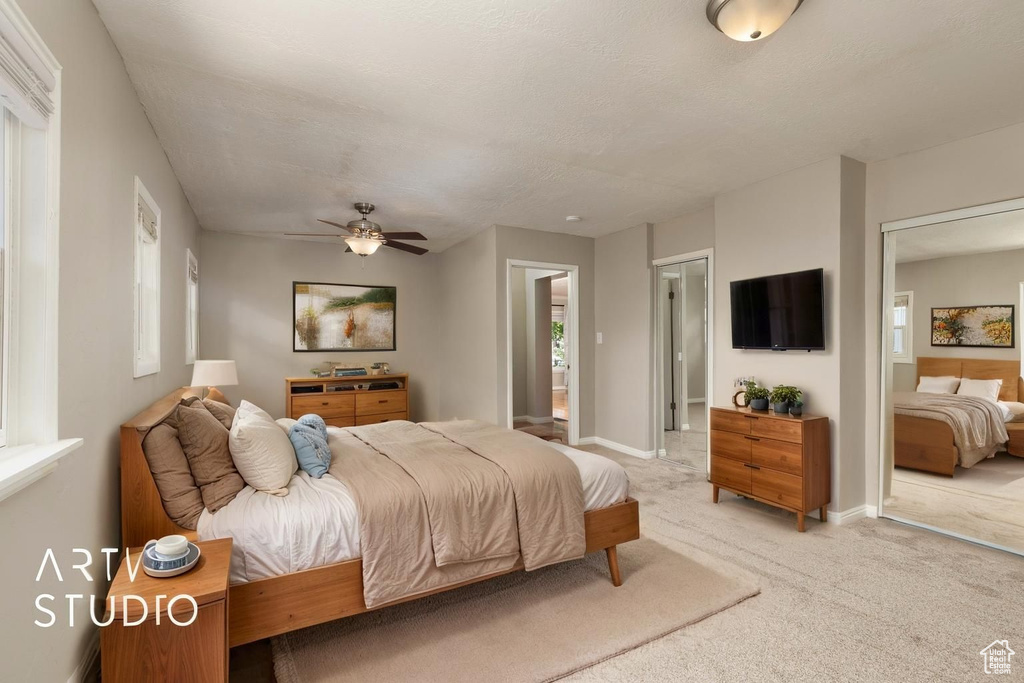Bedroom with baseboards, light carpet, and connected bathroom