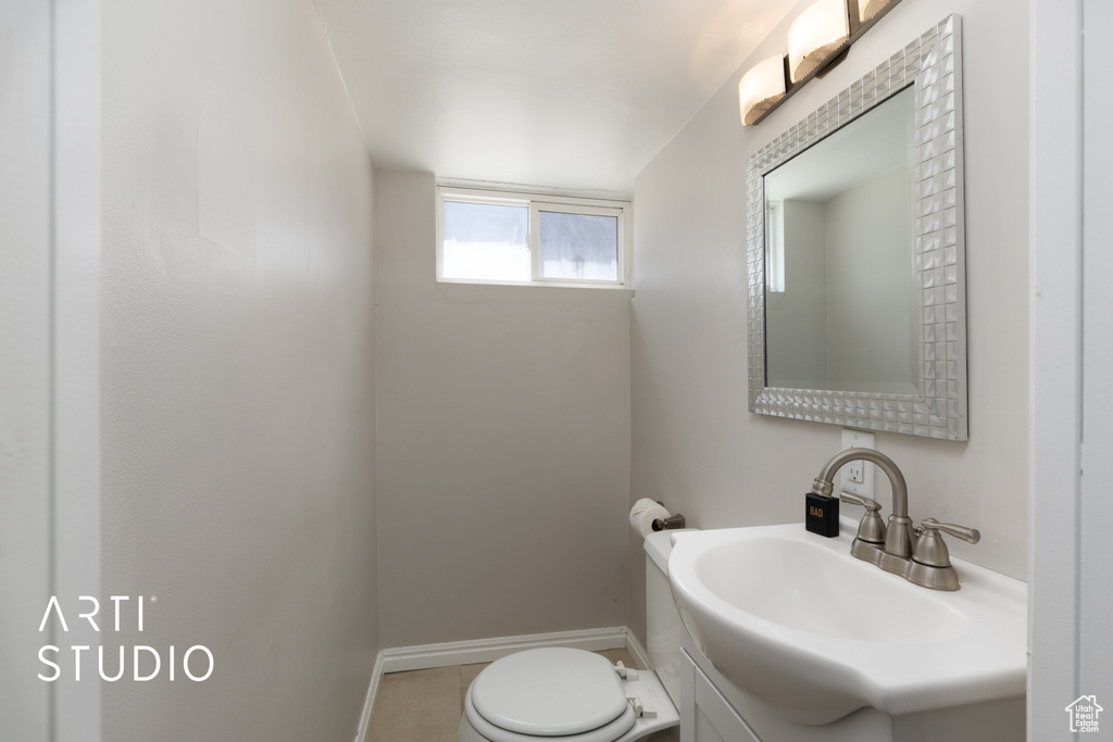 Bathroom with vanity, toilet, and baseboards