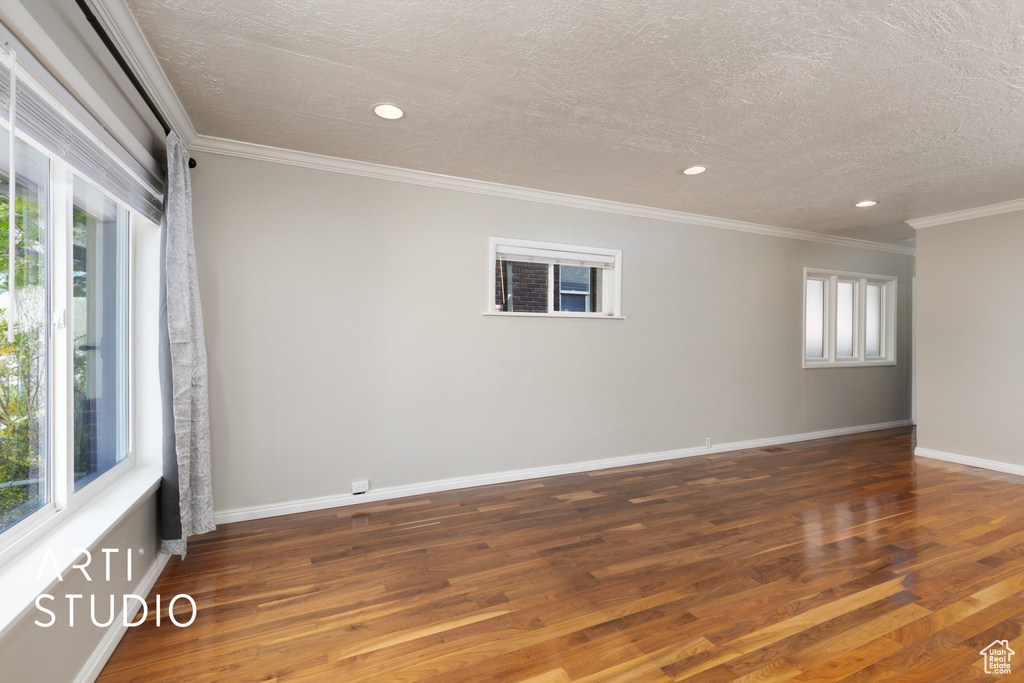 Unfurnished room featuring a textured ceiling, recessed lighting, and wood finished floors