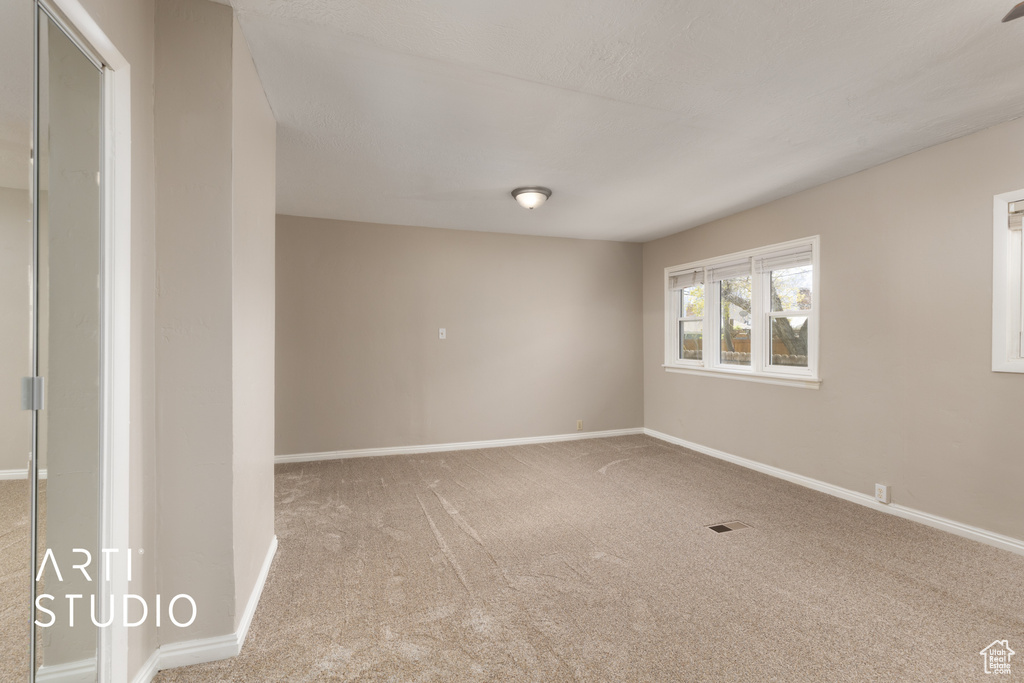 Unfurnished room with baseboards, visible vents, and carpet floors