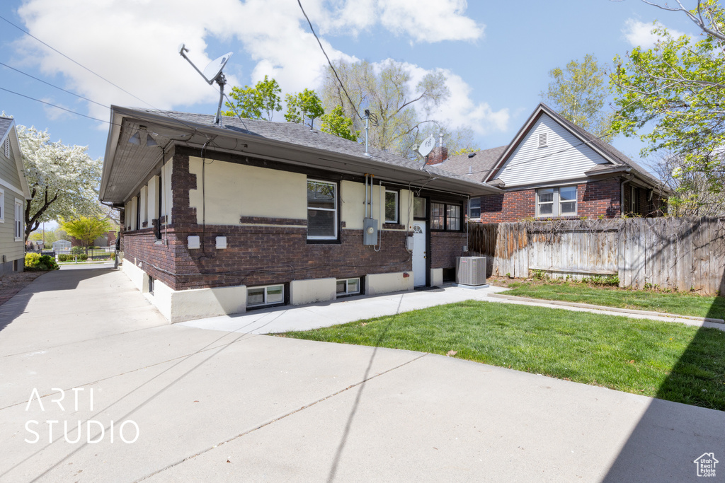 Single story home with a patio, central AC, fence, a front yard, and brick siding