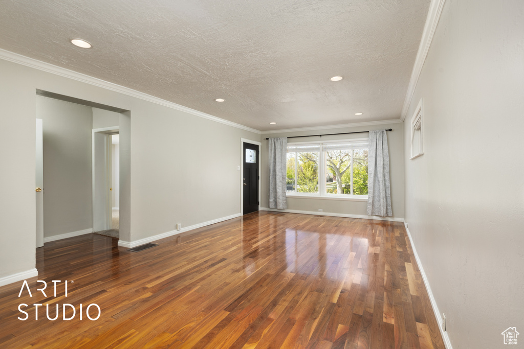 Empty room with ornamental molding, hardwood / wood-style flooring, and recessed lighting