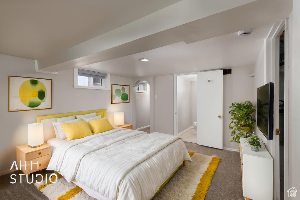Carpeted bedroom featuring baseboards and ensuite bath
