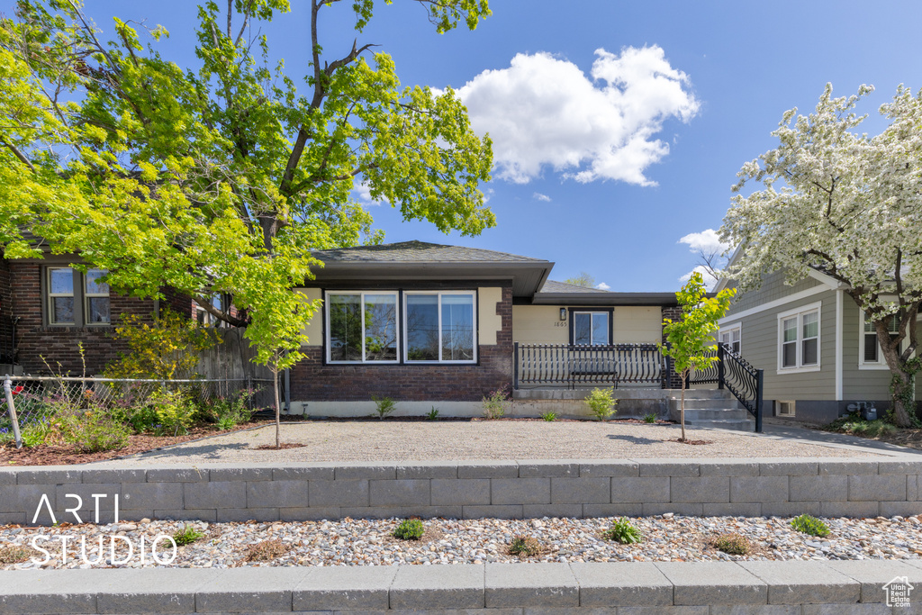 View of front of house with fence and brick siding
