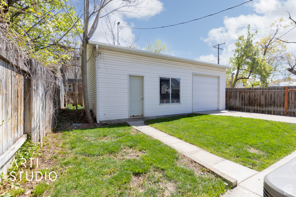 Garage with concrete driveway and fence