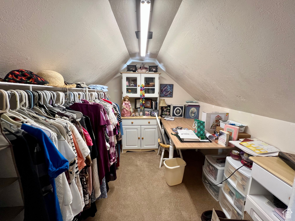 Spacious closet with lofted ceiling and light carpet