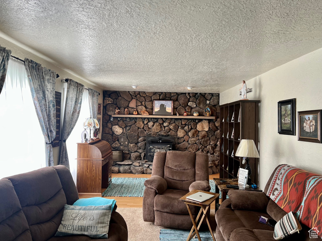 Living area featuring a textured ceiling, wood finished floors, and a fireplace