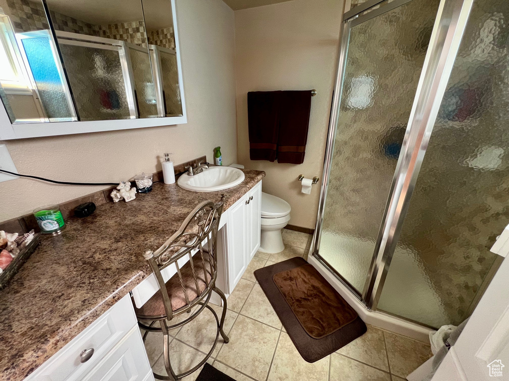 Full bath with vanity, toilet, tile patterned flooring, and a stall shower