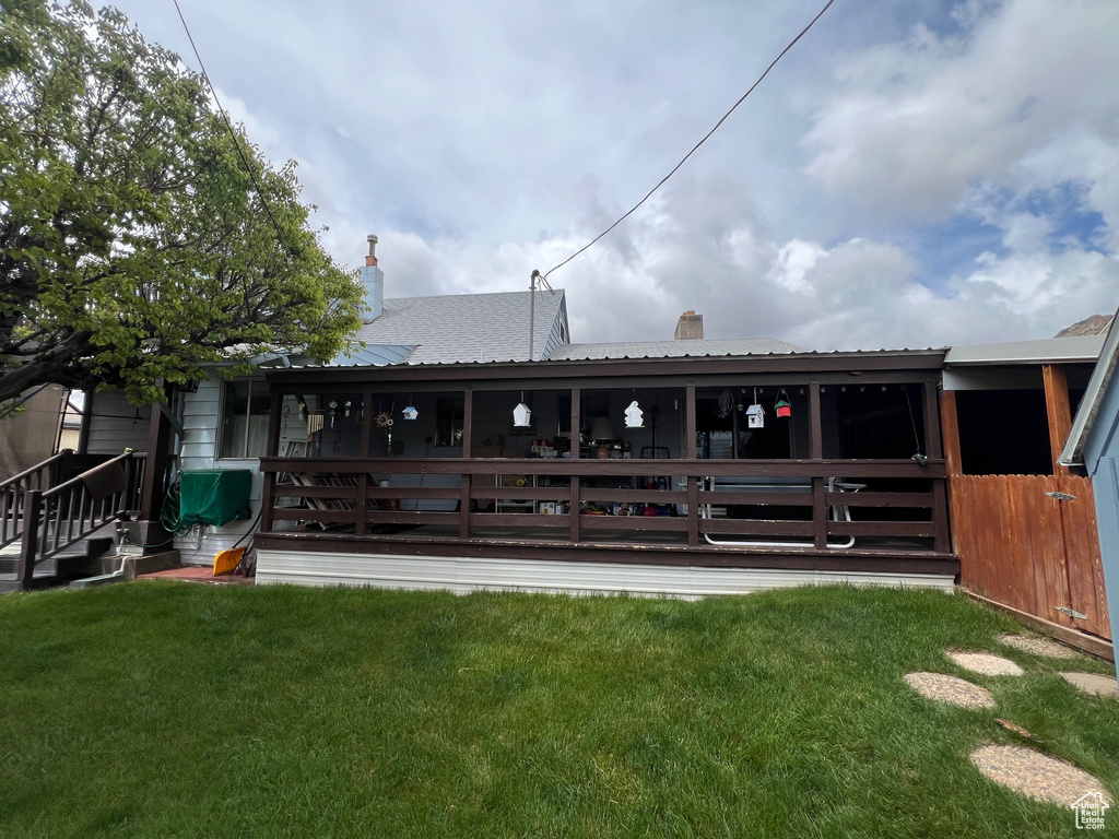 Rear view of property featuring metal roof, a yard, and a chimney