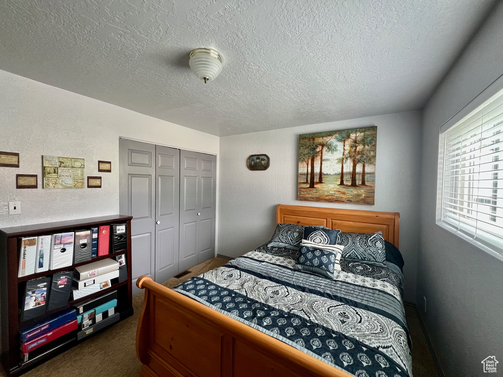 Bedroom featuring a textured ceiling and a closet