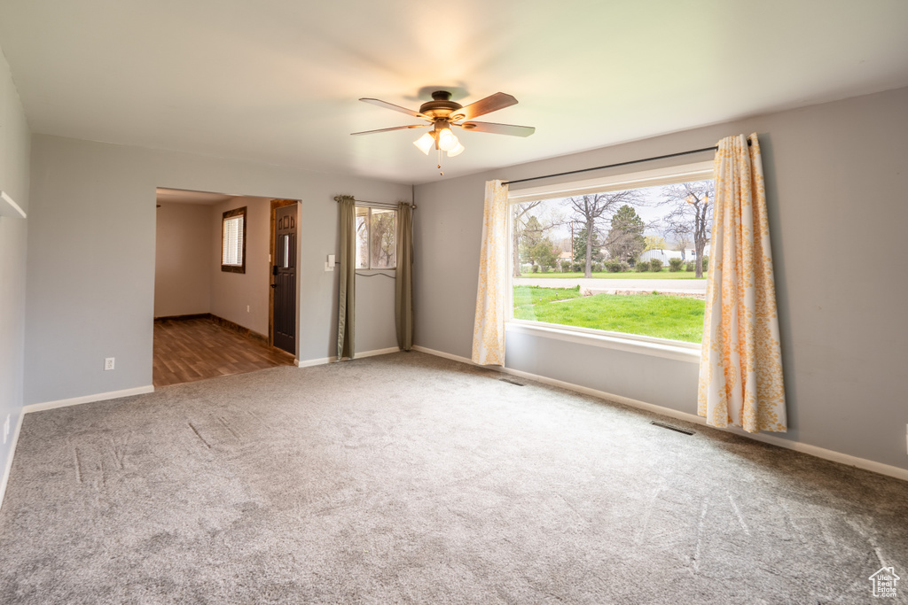 Spare room with ceiling fan, carpet flooring, baseboards, and visible vents