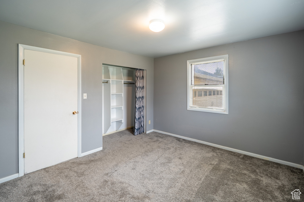 Unfurnished bedroom with a closet, baseboards, and carpet floors