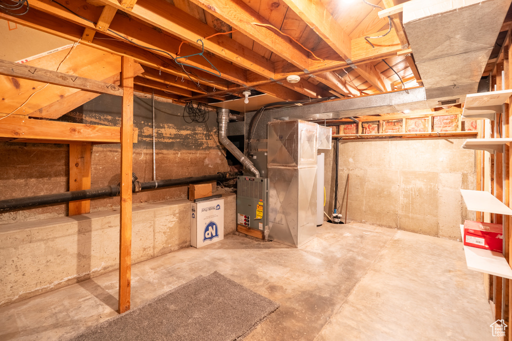 Unfinished below grade area featuring heating unit