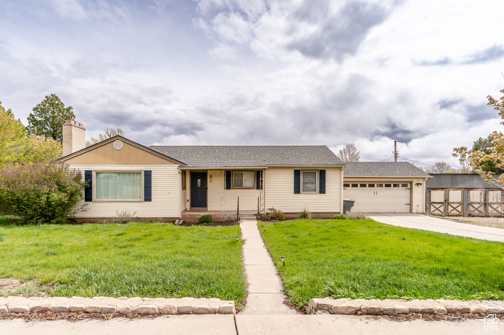View of front of property with roof with shingles, concrete driveway, an attached garage, and a front yard