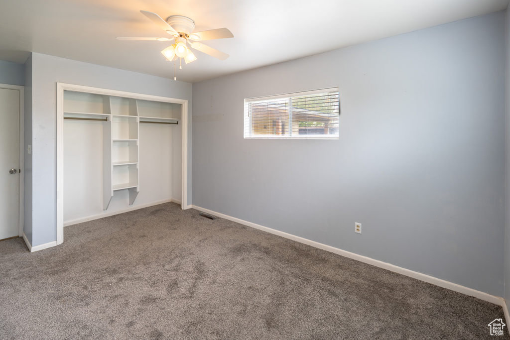 Unfurnished bedroom featuring ceiling fan, carpet flooring, a closet, and baseboards
