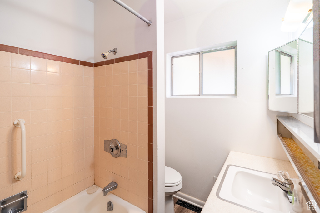 Bathroom featuring toilet, vanity, and tub / shower combination