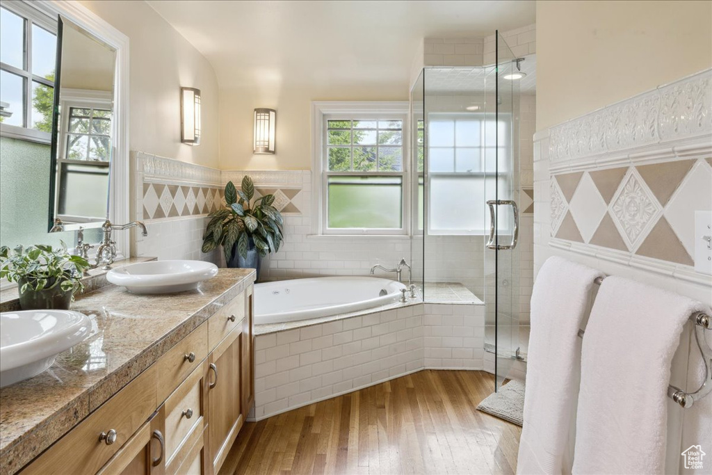 Full bathroom with a sink, a bath, hardwood / wood-style floors, and plenty of natural light