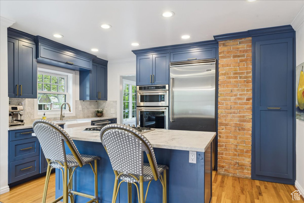 Kitchen featuring a sink, ornamental molding, decorative backsplash, and double oven
