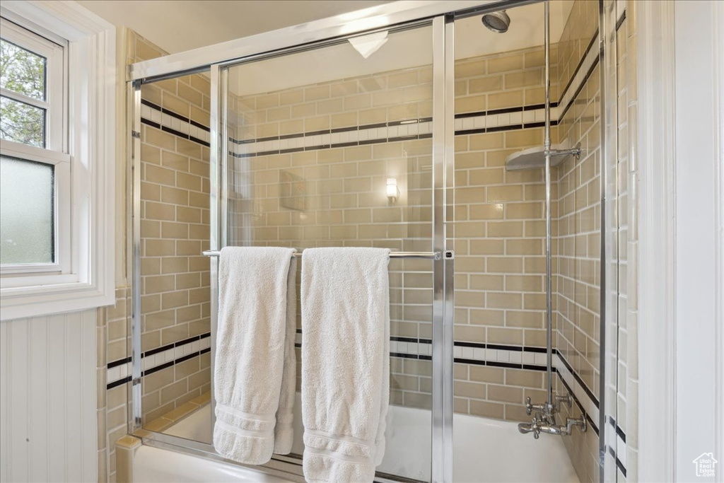 Bathroom with combined bath / shower with glass door