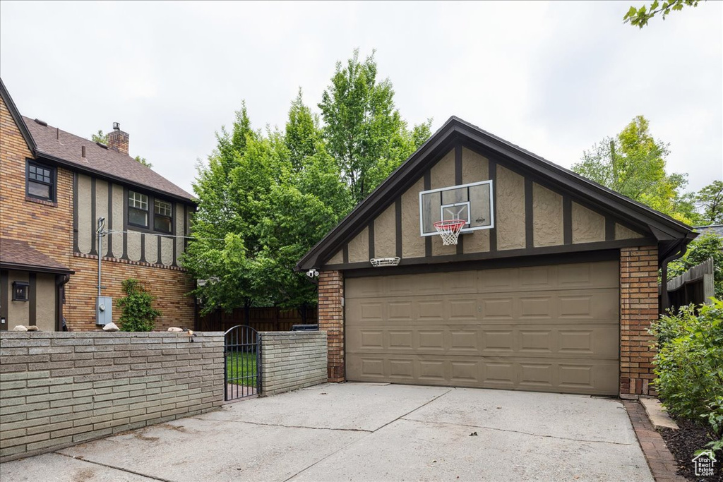 Garage featuring fence and a gate