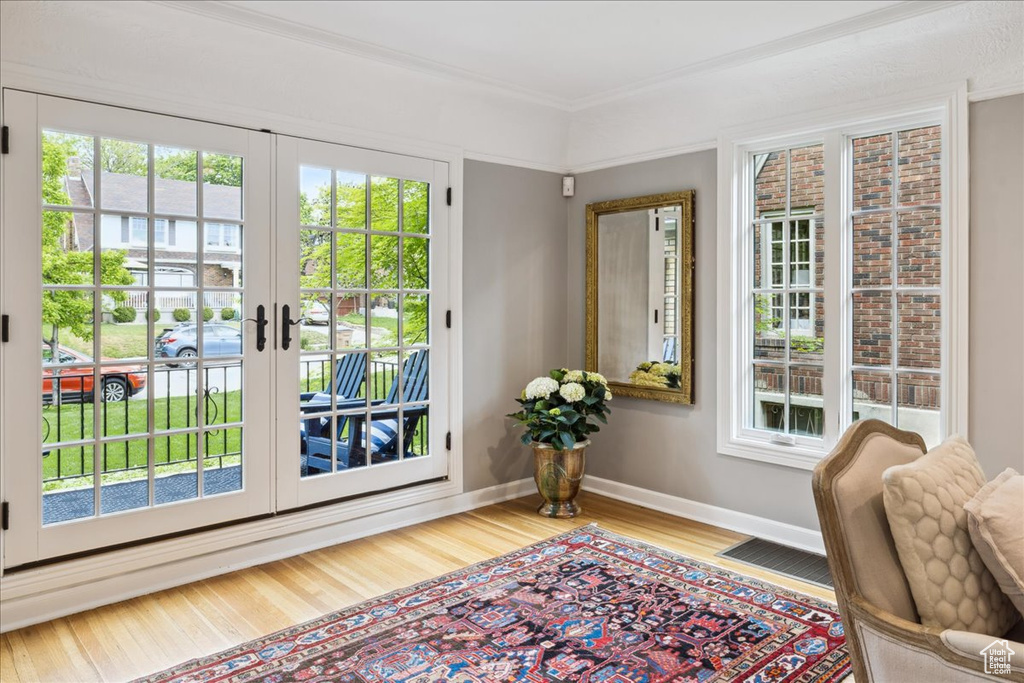 Doorway with baseboards, french doors, plenty of natural light, and wood finished floors