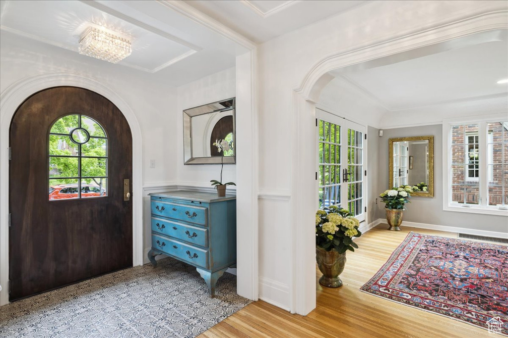 Foyer entrance with arched walkways, a wealth of natural light, and wood finished floors