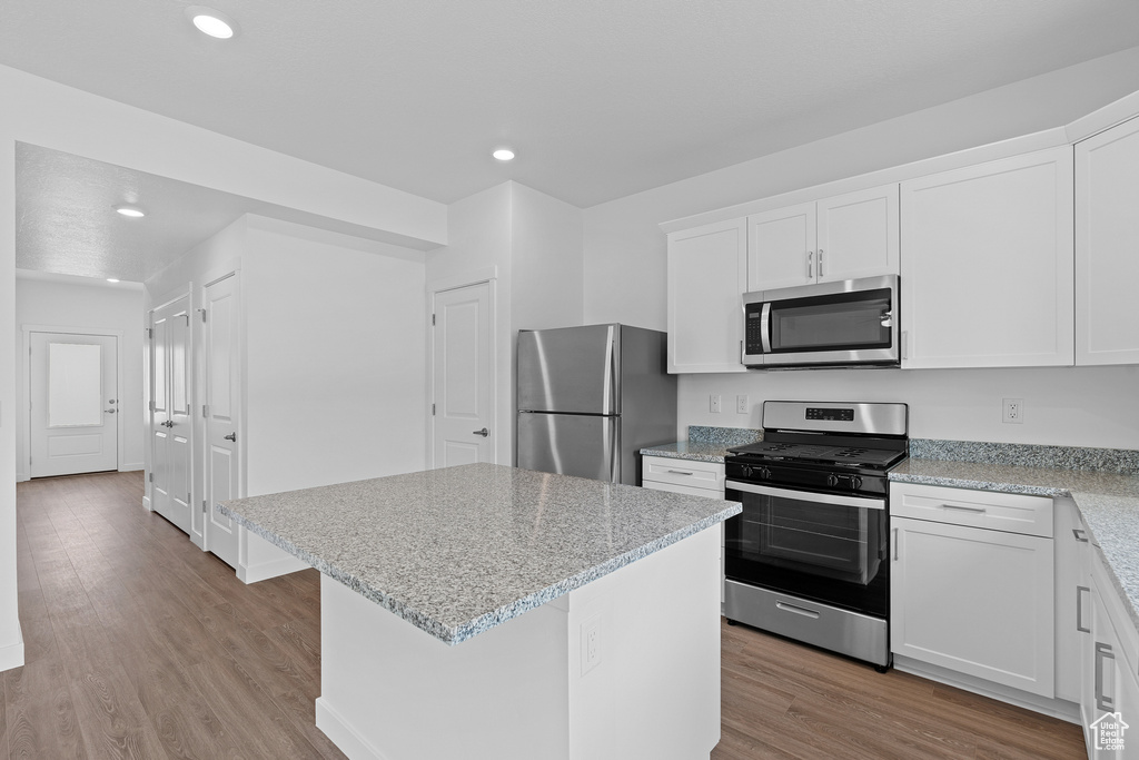 Kitchen featuring recessed lighting, a center island, light wood-style floors, stainless steel appliances, and white cabinets